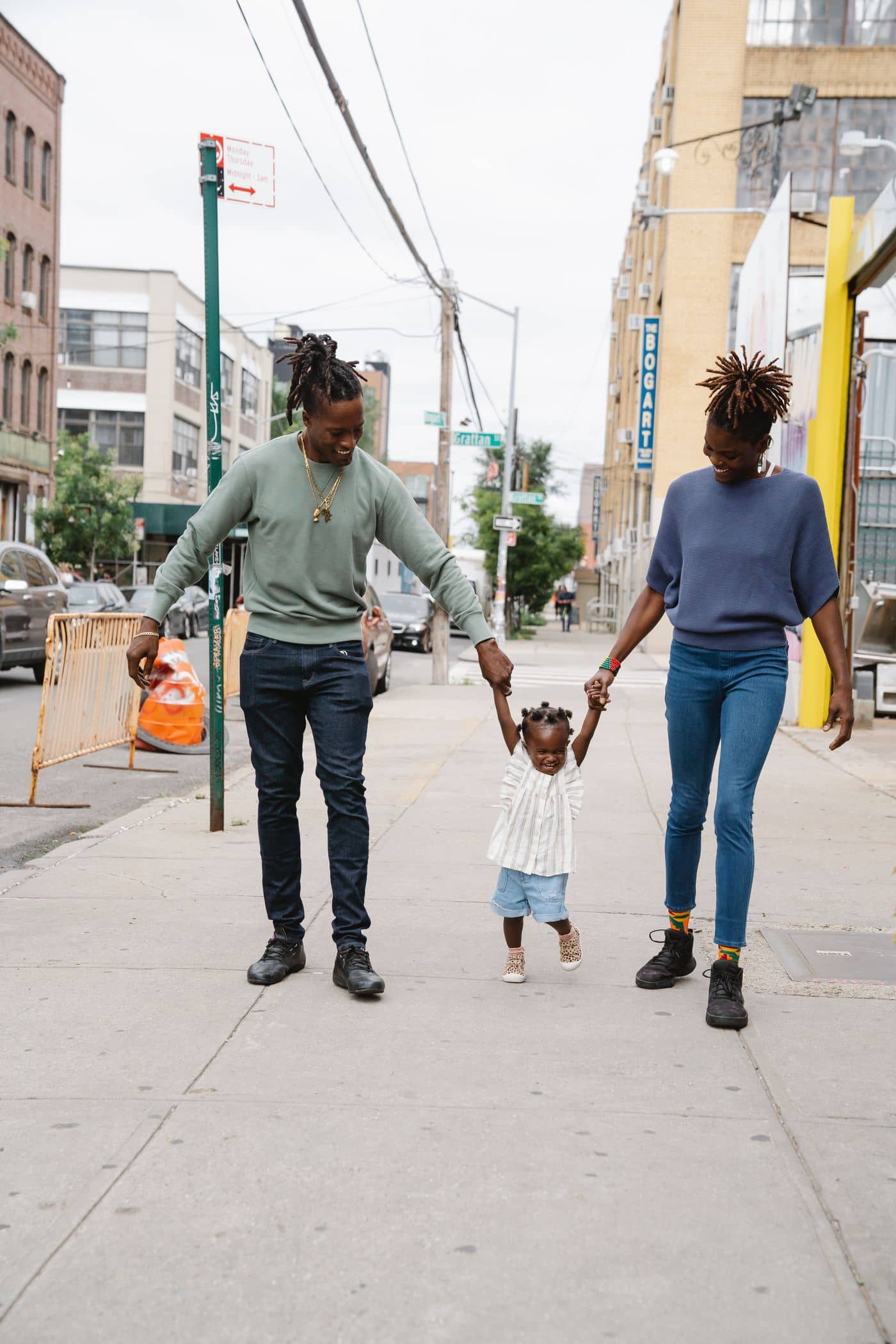 Parents walking hand in hand with their toddler
