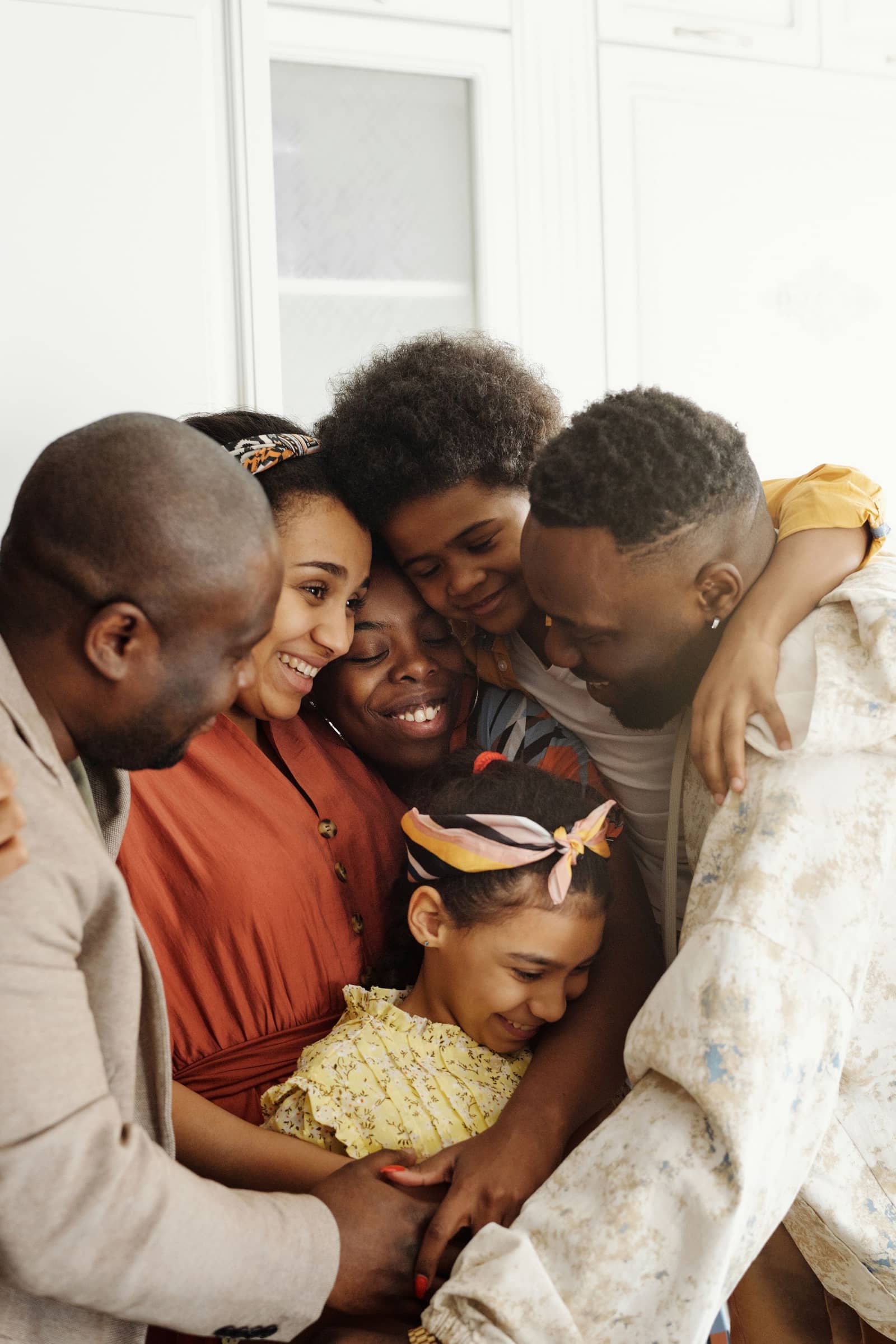 A smiling Black family hugging together at home