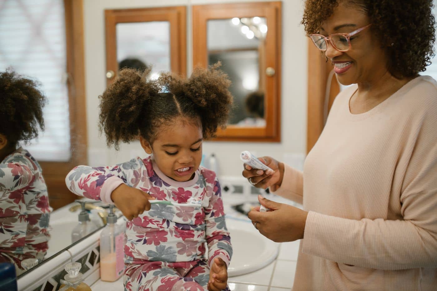Mother and daughter brushing teeth in the morning